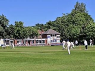 View of the field, players and clubhouse of the Moorlands cricket club in Mirfield